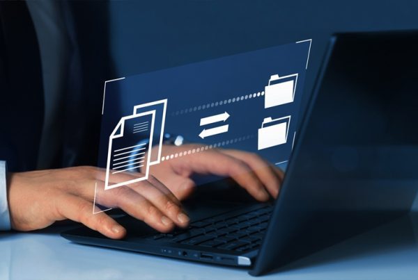 A person typing on a laptop with digital icons of folders and a document, representing data backup and recovery or file sharing, displayed above the keyboard.